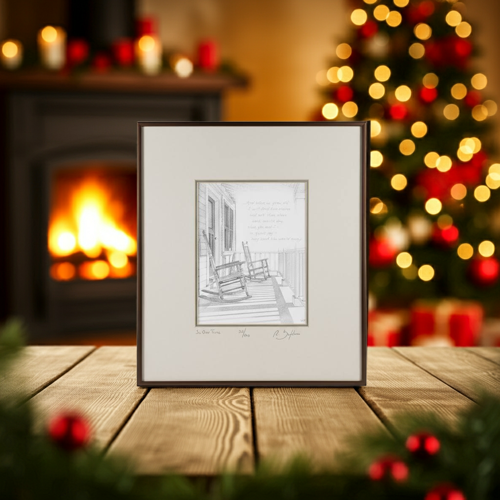 Framed black and white print of a porch scene with rocking chairs on a wooden table with a Christmas tree and fireplace in the background