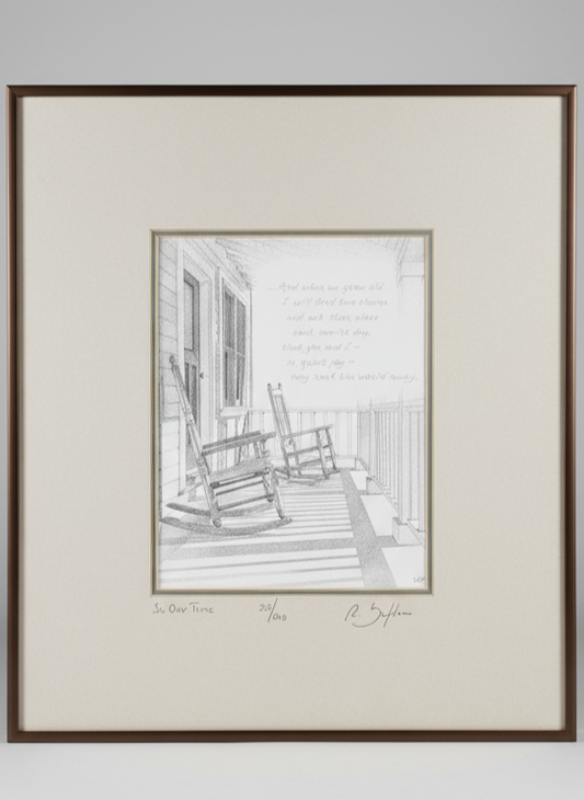 Framed black and white print of a porch scene with rocking chairs