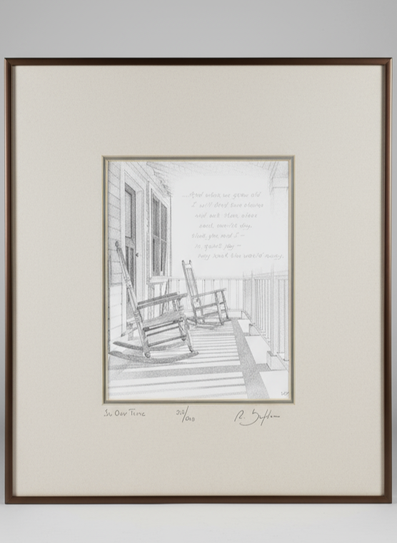 Framed black and white print of a porch scene with rocking chairs