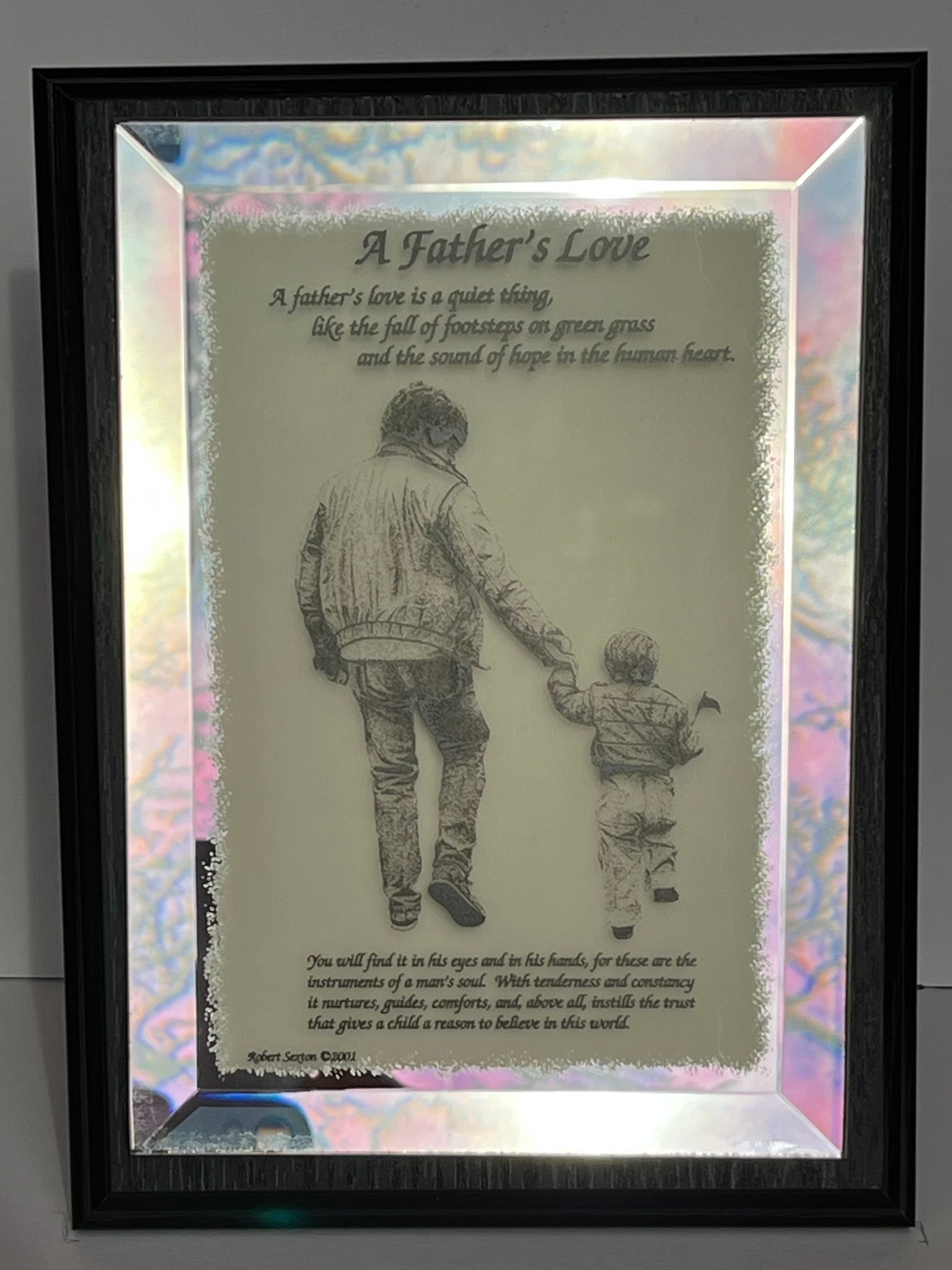 Framed artwork of a father and child holding hands with a quote about father's love.