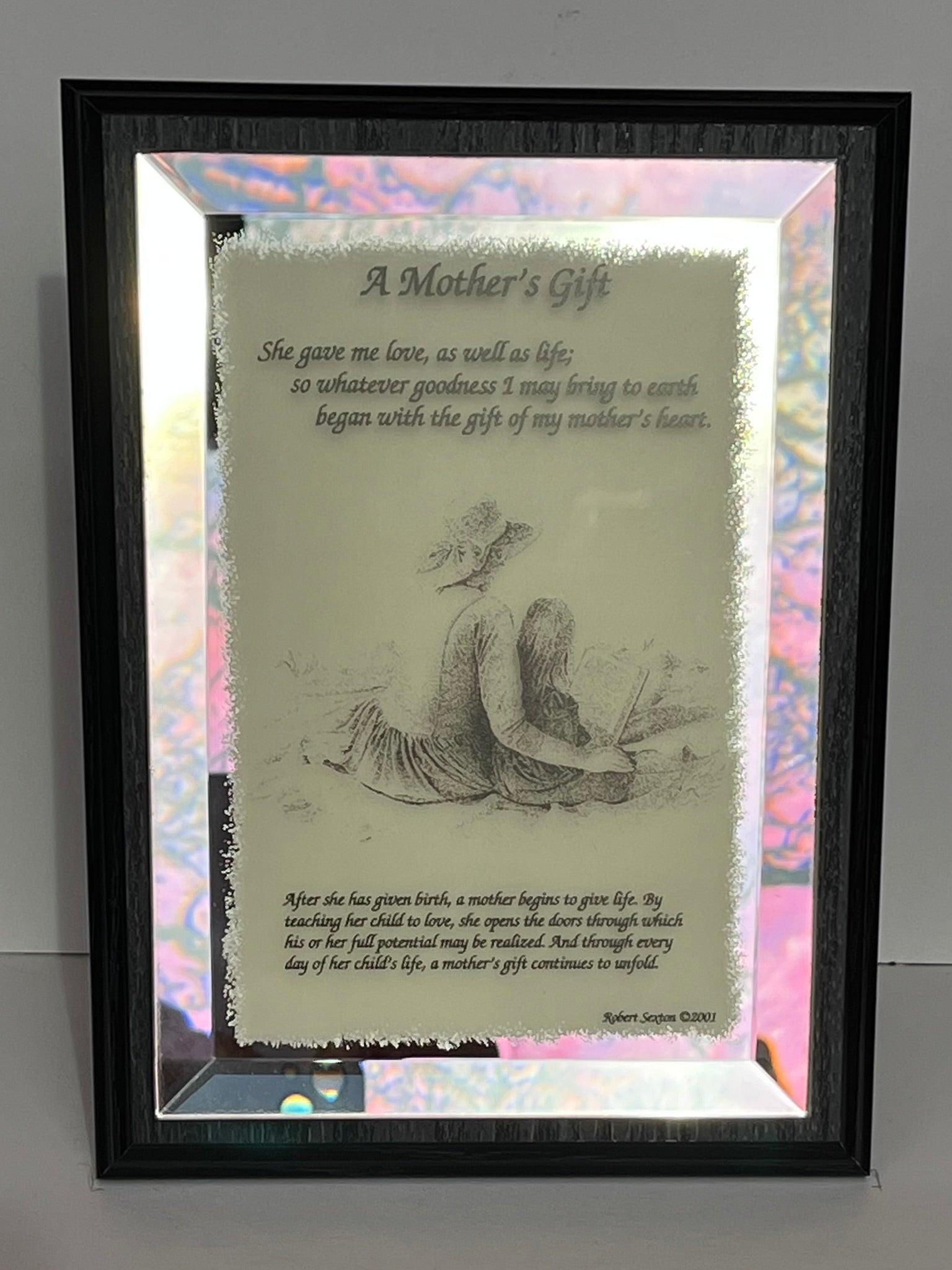 Framed print with a mother and child illustration and poem on a reflective surface