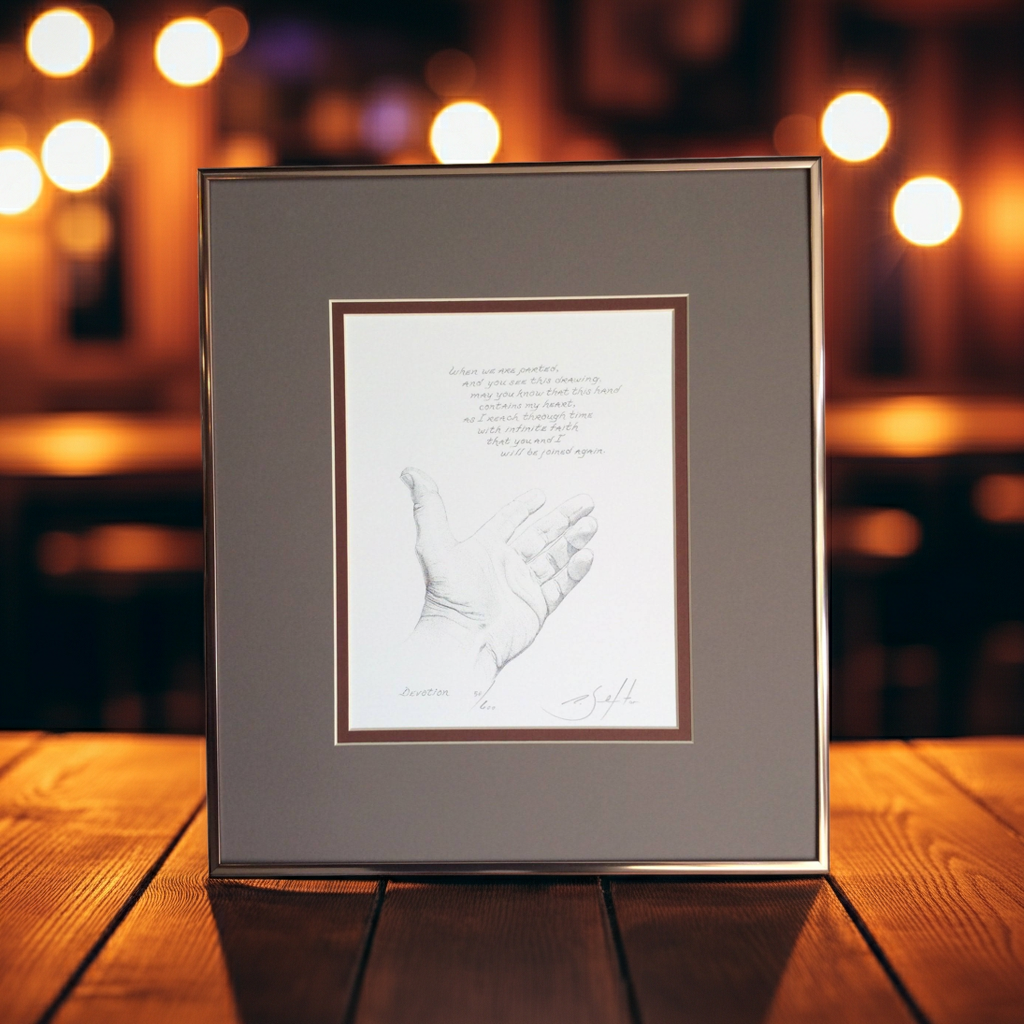 Framed artwork of a handprint on a wooden surface with blurred lights in the background