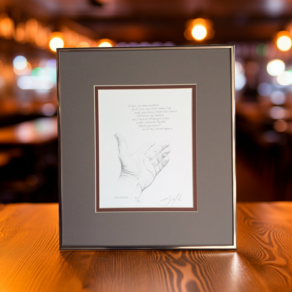 Framed artwork of a handprint on a wooden surface with a blurred background