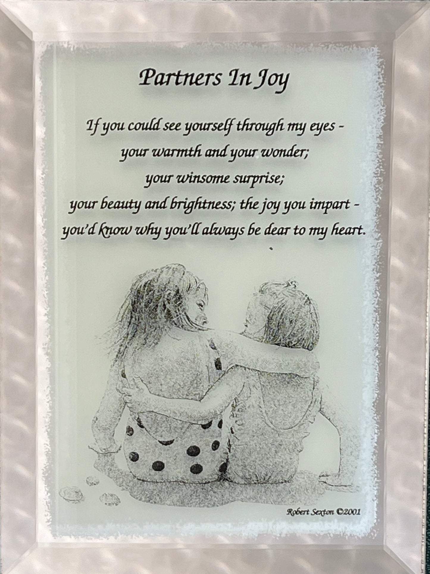 Framed artwork with a couple hugging and a romantic poem titled 'Partners In Joy'.