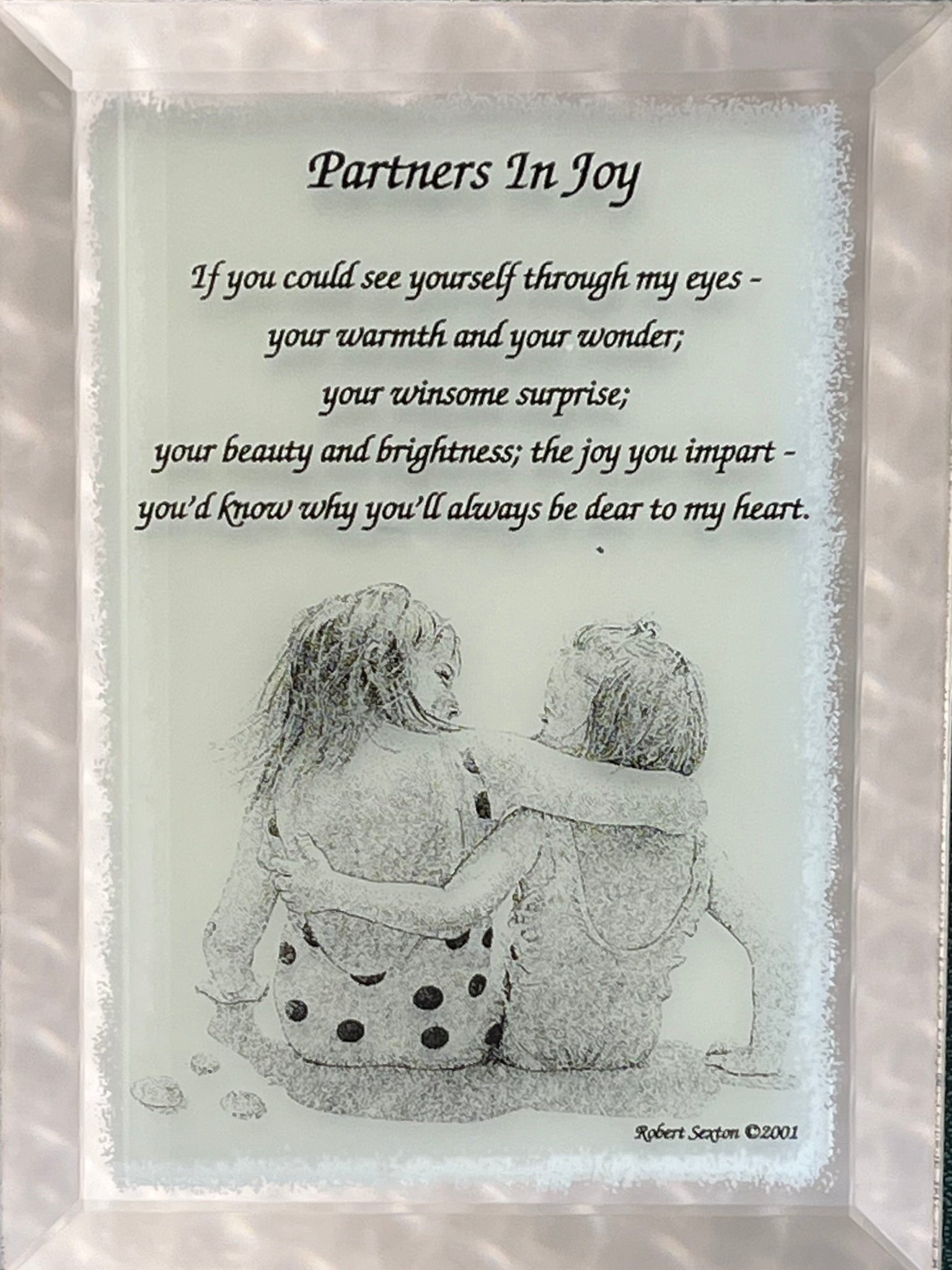 Framed artwork with a couple hugging and a romantic poem titled 'Partners In Joy'.