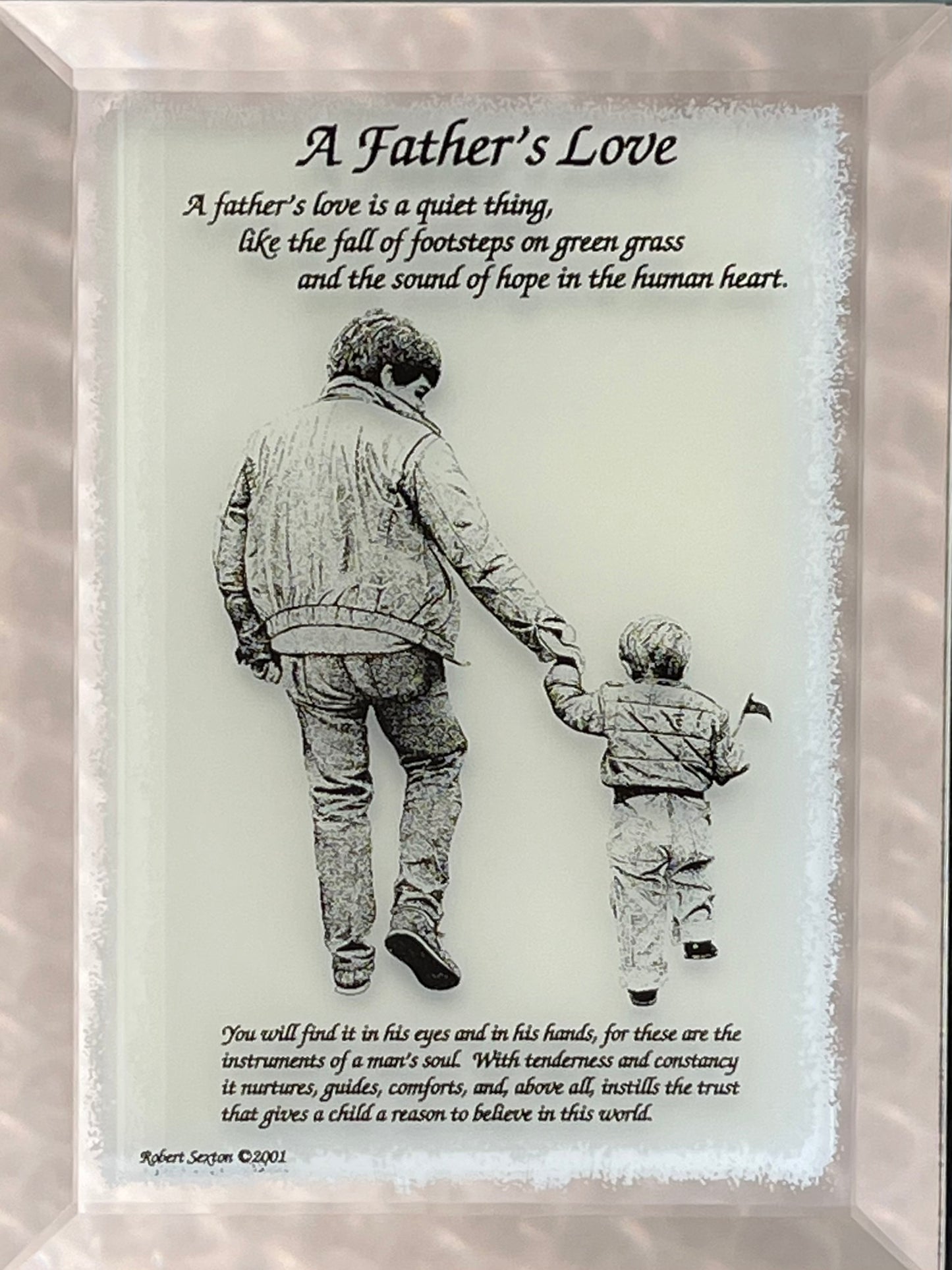 Framed artwork of a father and son holding hands with a quote about father's love.
