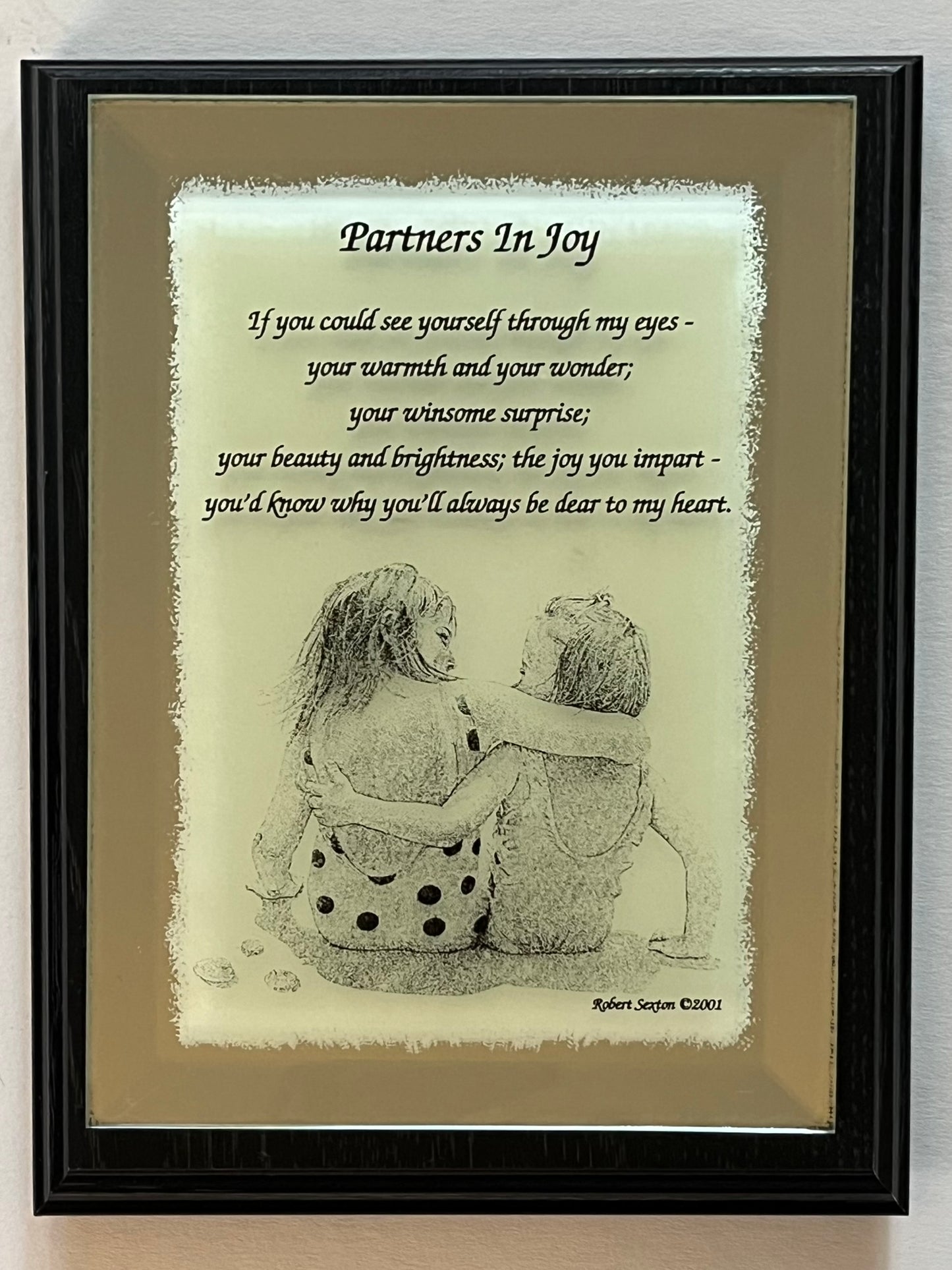Framed artwork with a couple hugging and a romantic poem titled 'Partners In Joy'.