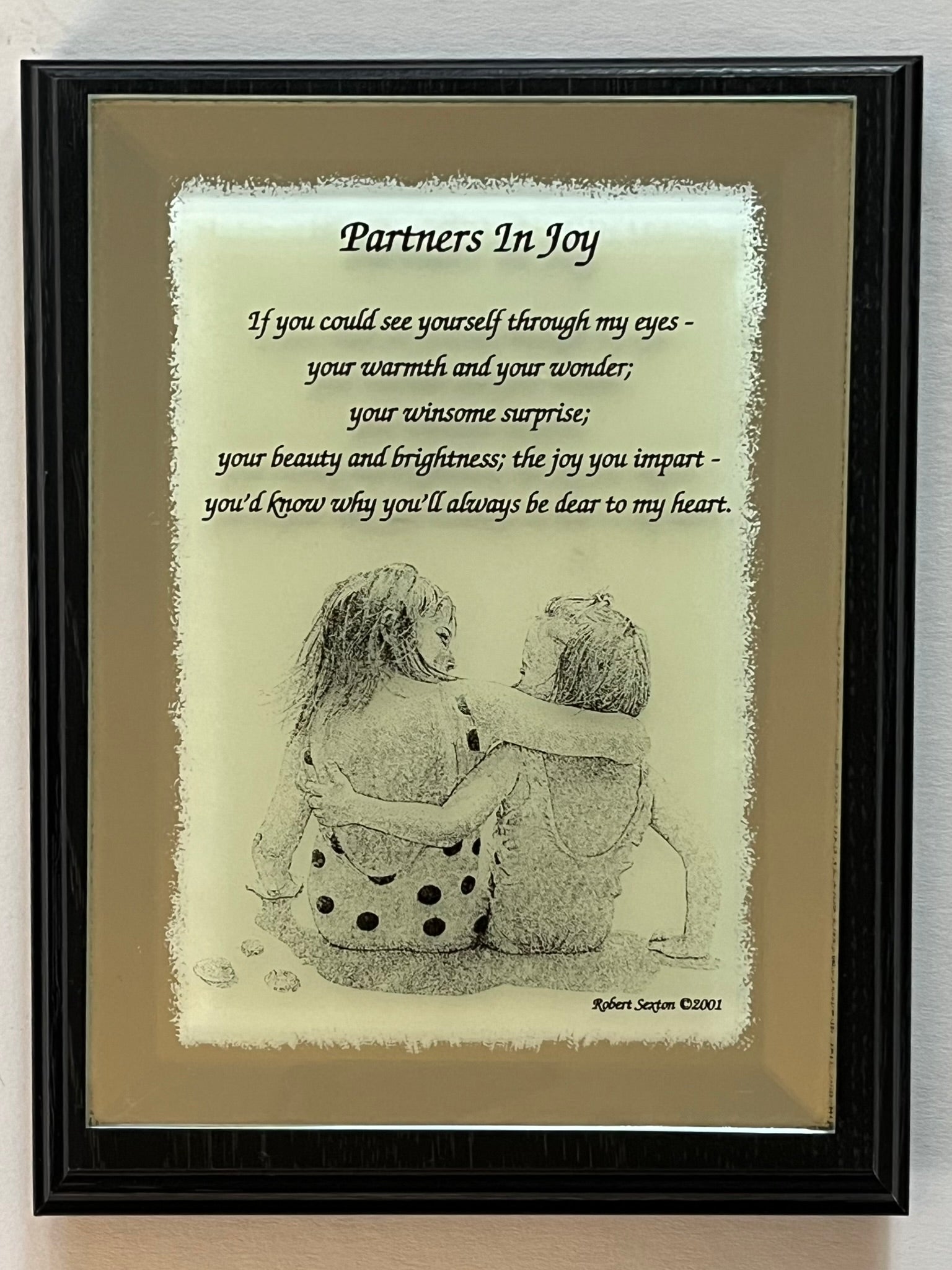 Framed artwork with a couple hugging and a romantic poem titled 'Partners In Joy'.