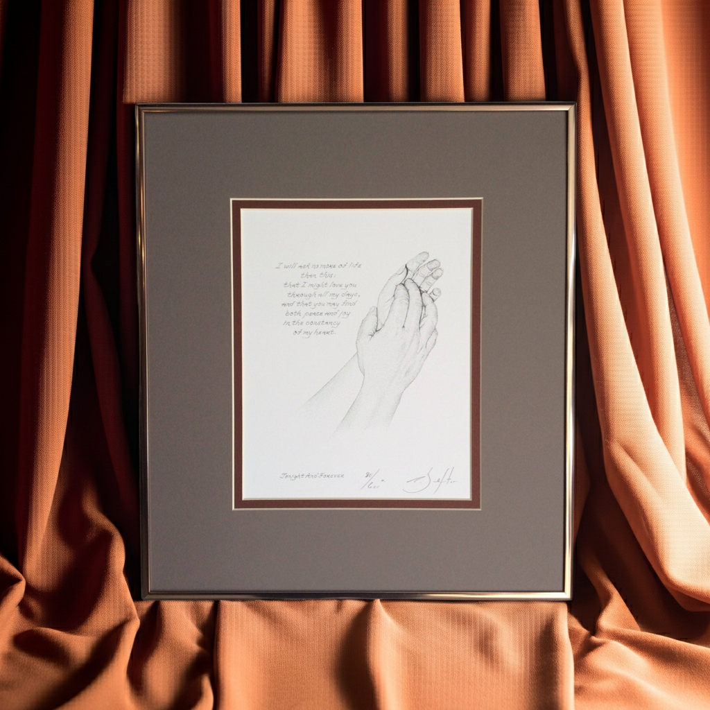 Framed artwork of holding hands against a brown curtain background